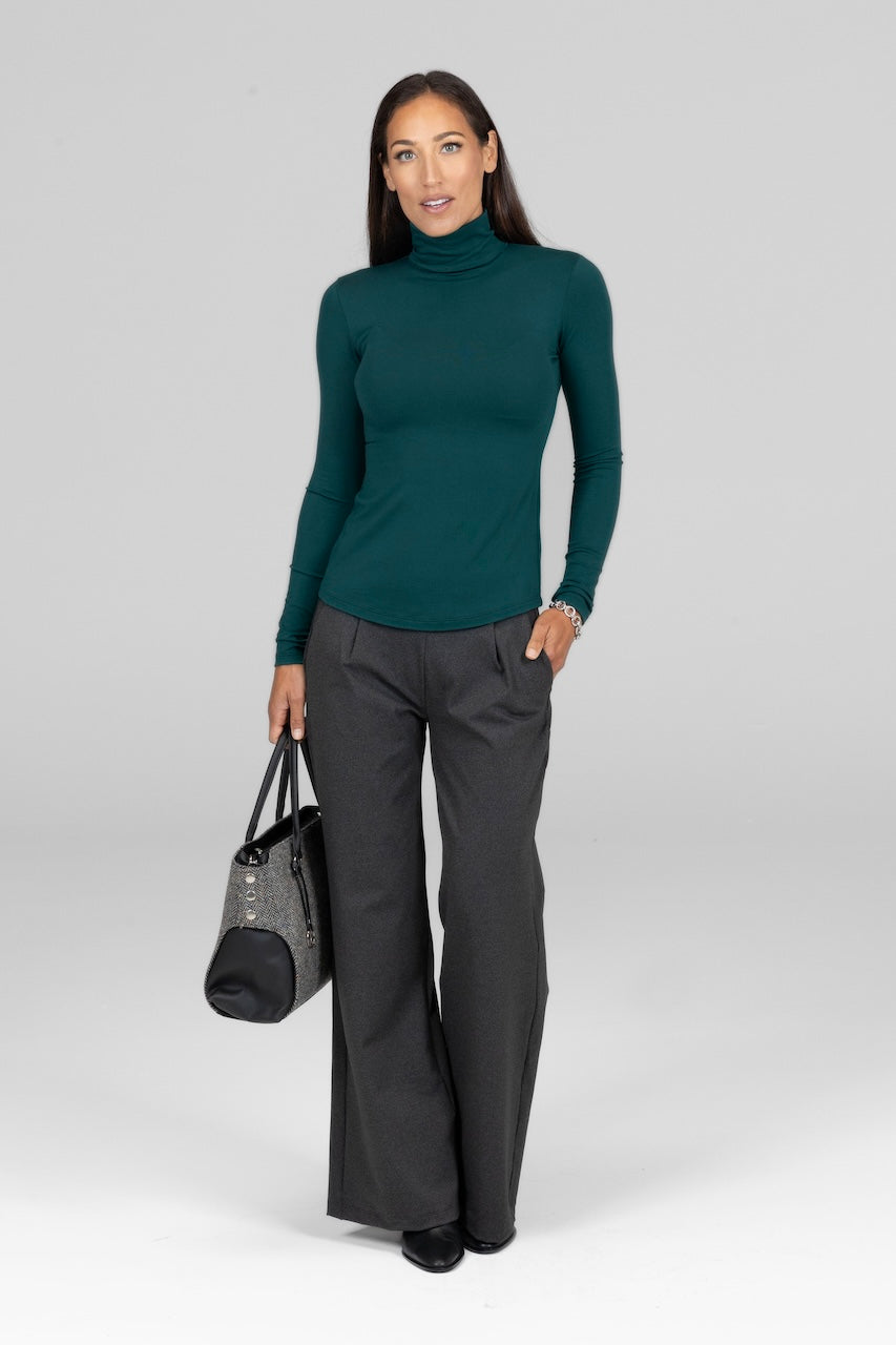 Model wearing emerald Grace Turtleneck, styled with a wide leg pant for an elegant and polished look.