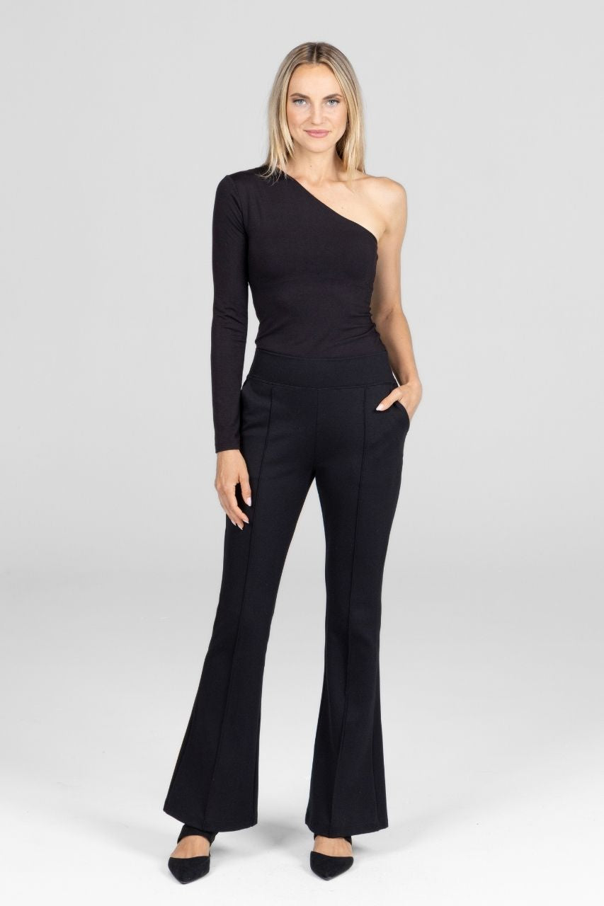 Woman wearing black pintcuk flare pants and black one sleeve top