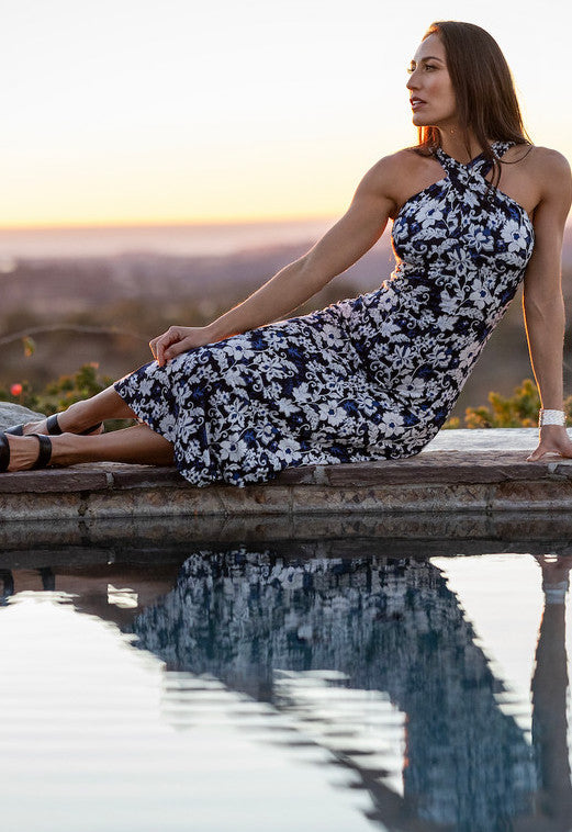 Model sitting in a side pose LUXE HALTER MIDI DRESS: LILY IKAT