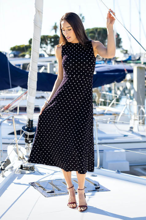 Model on a boat in BOATNECK MIDI DRESS: NAVY DOT