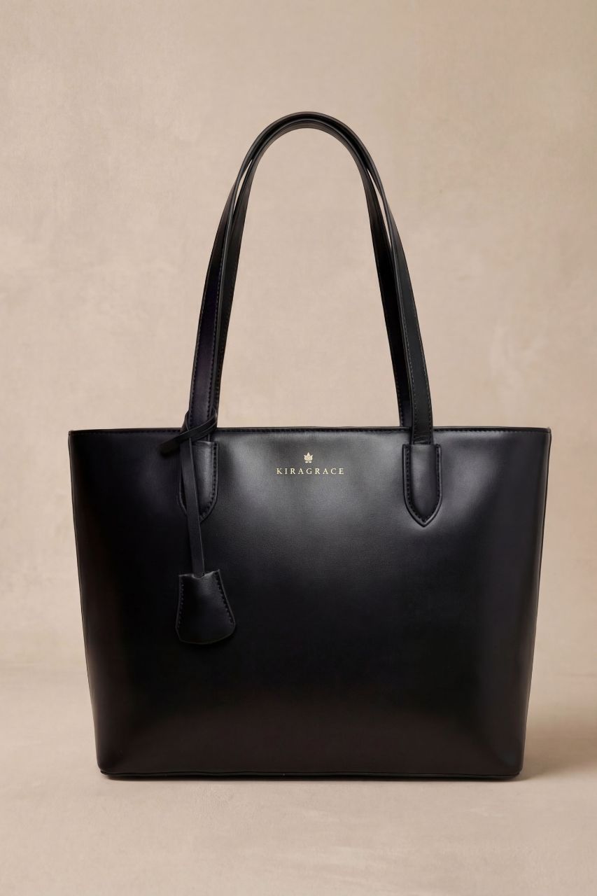 Black handbag with KiraGrace brand logo on a beige background