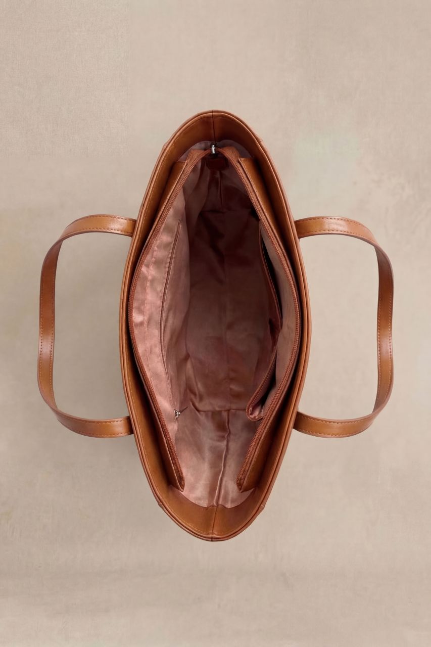 Inside view of a brown PU leather tote bag on a beige background