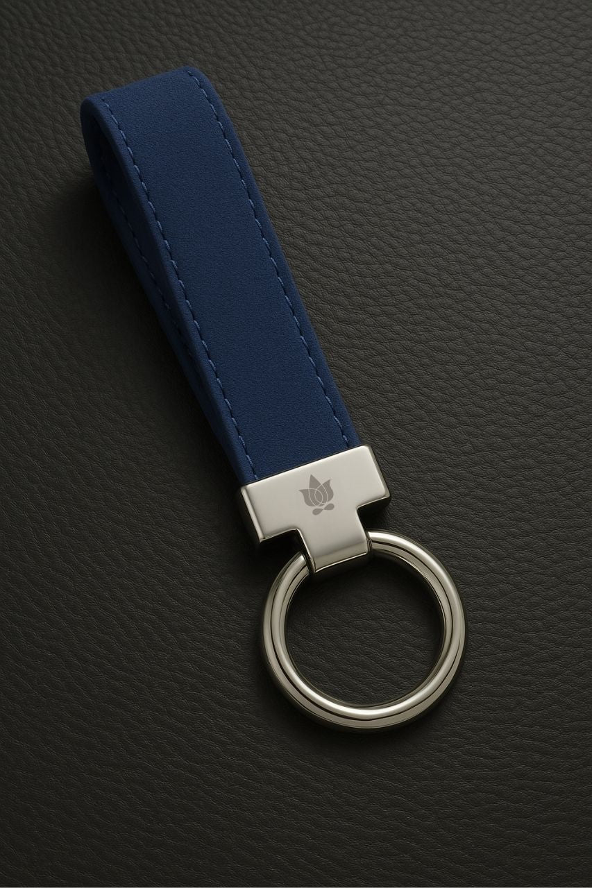 Blue suede keychain with silver metal tag on a dark textured background