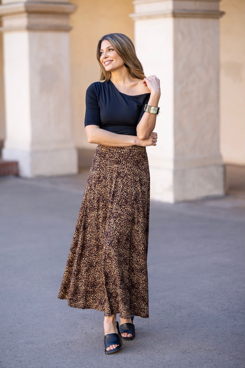 Woman wearing black off the shoulder top with leopard print maxi skirt