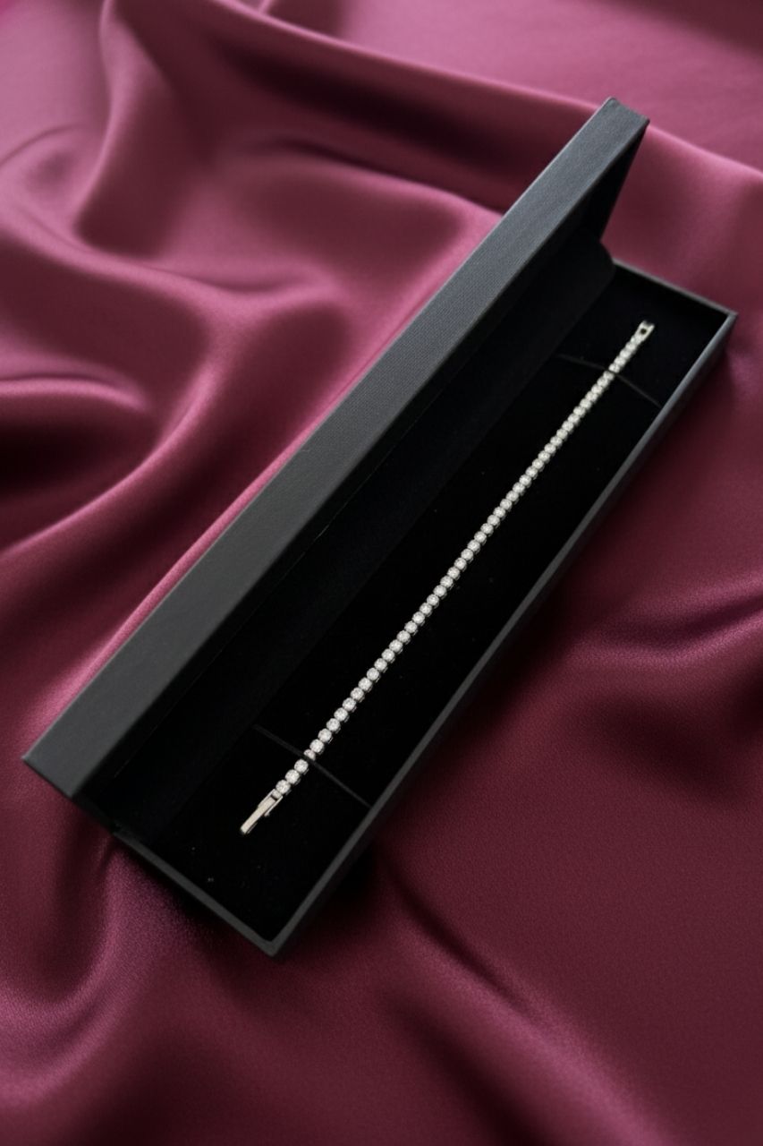 Black jewelry box with a silver bracelet on a burgundy fabric background