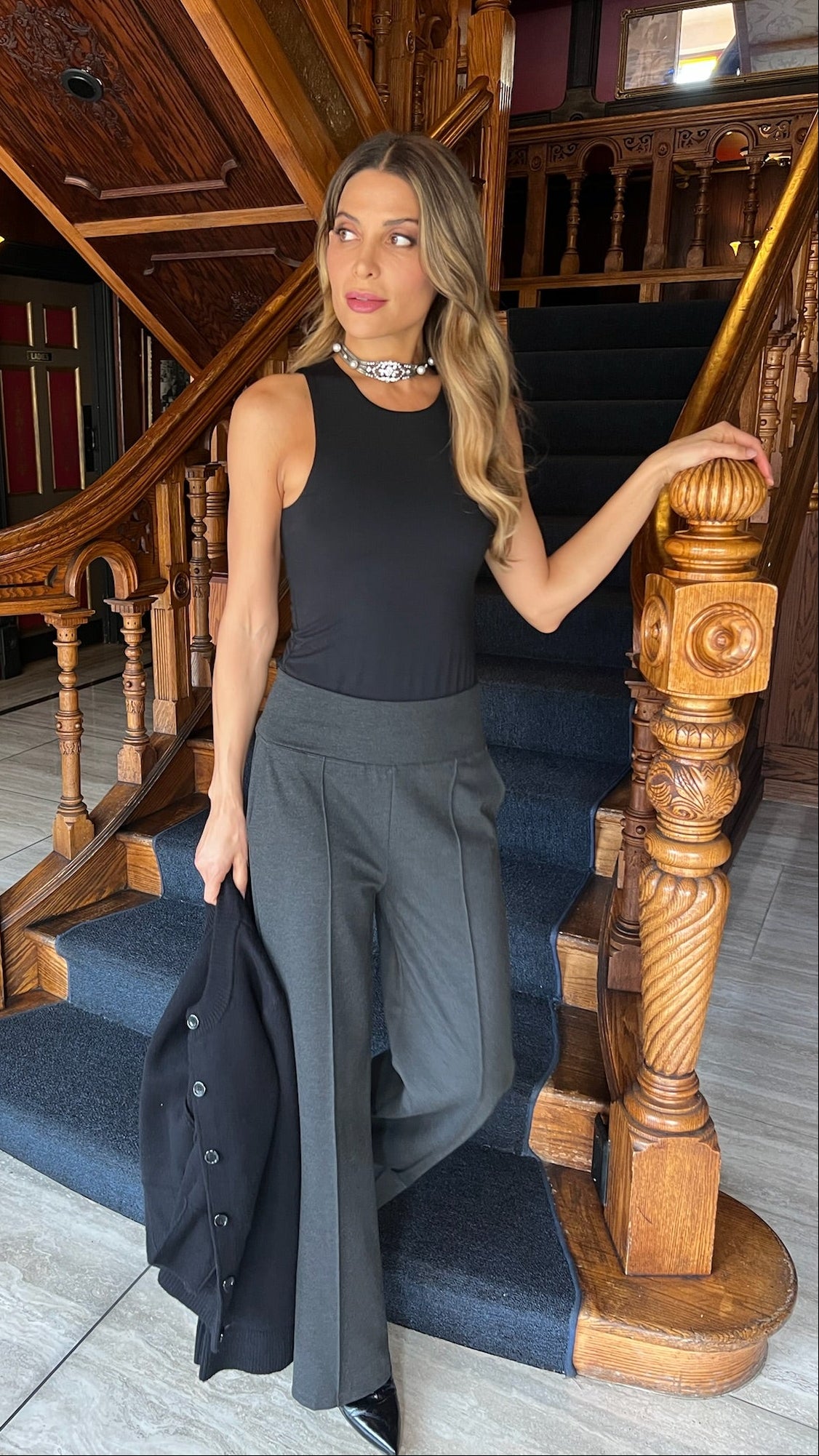 Woman standing on a staircase in an elegant interior setting