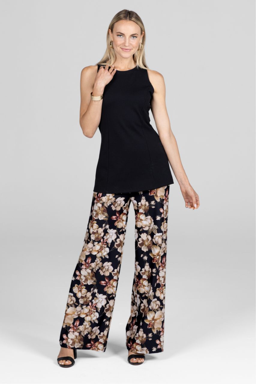 Woman wearing a black sleeveless tunic and floral wide leg pants