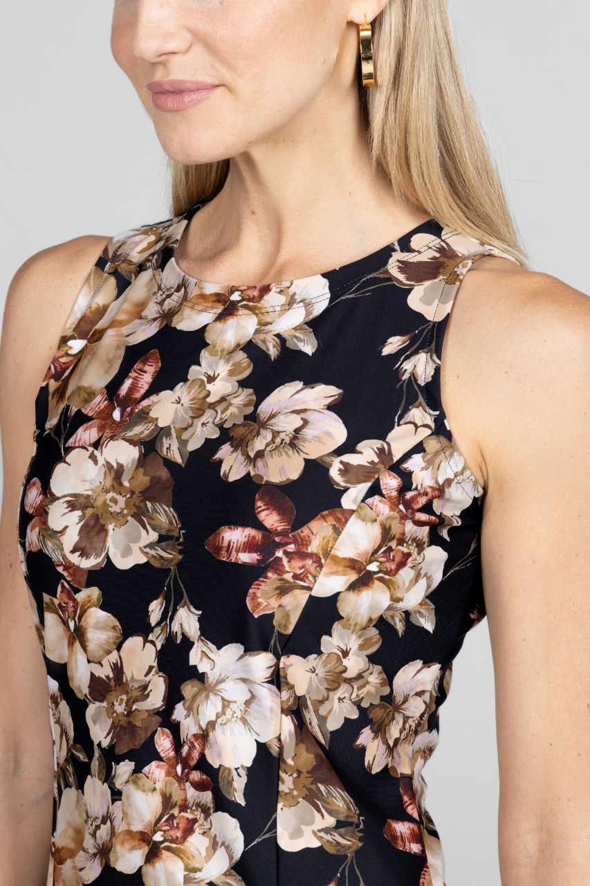 Woman wearing a sleeveless tailored tunic with a floral pattern on a plain background