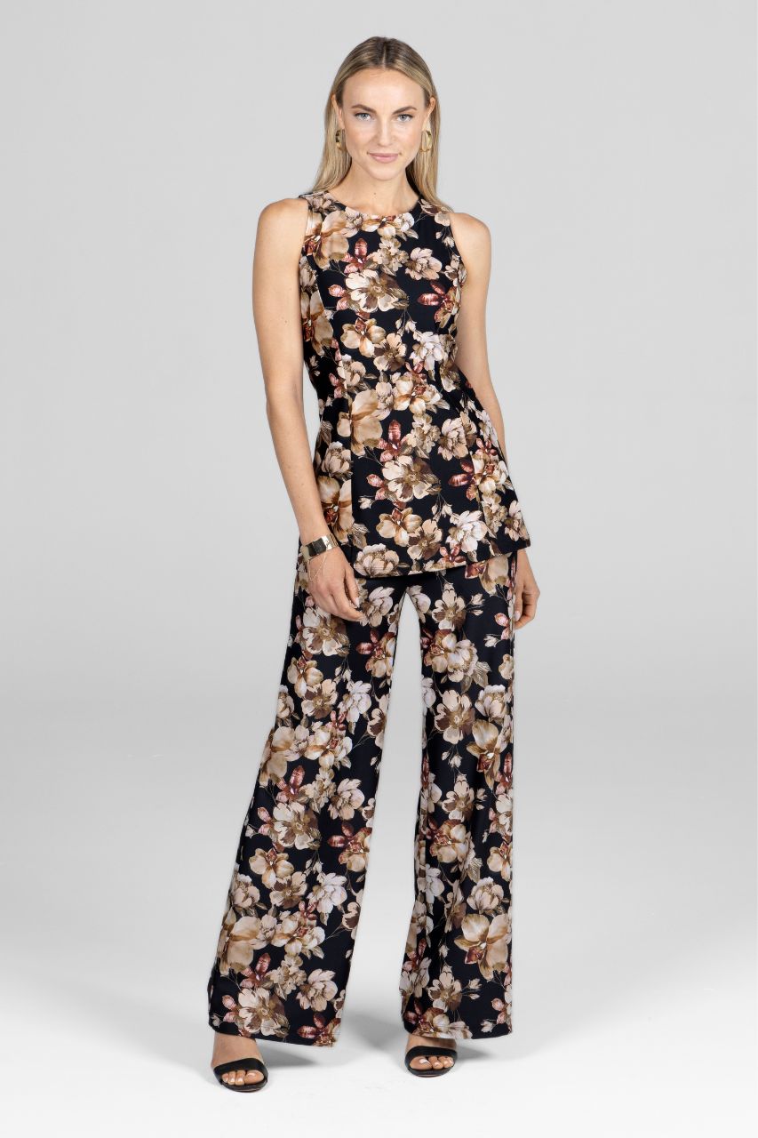 Woman wearing a floral two piece set with a floral tunic and floral wide leg pants on a studio background