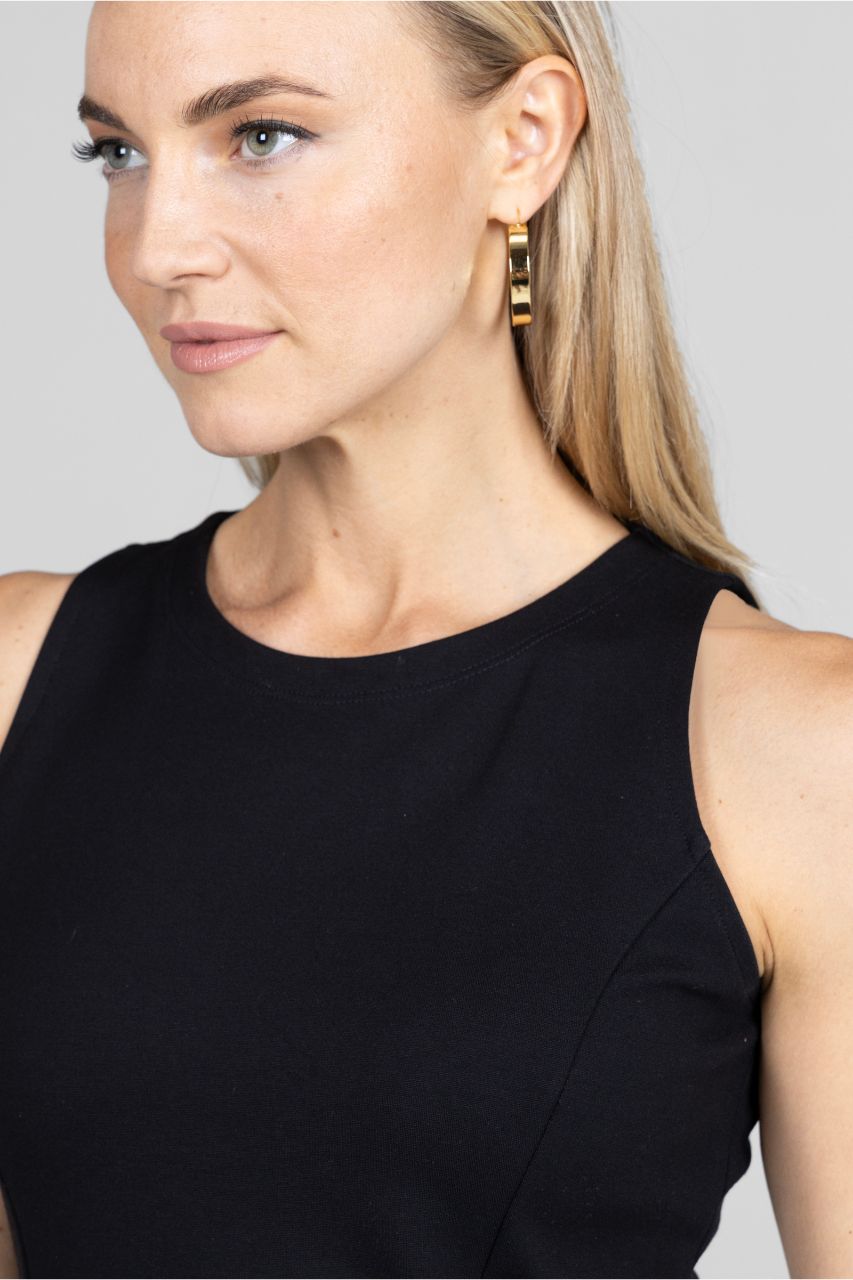 Close up view of woman wearing black sleeveless tunic