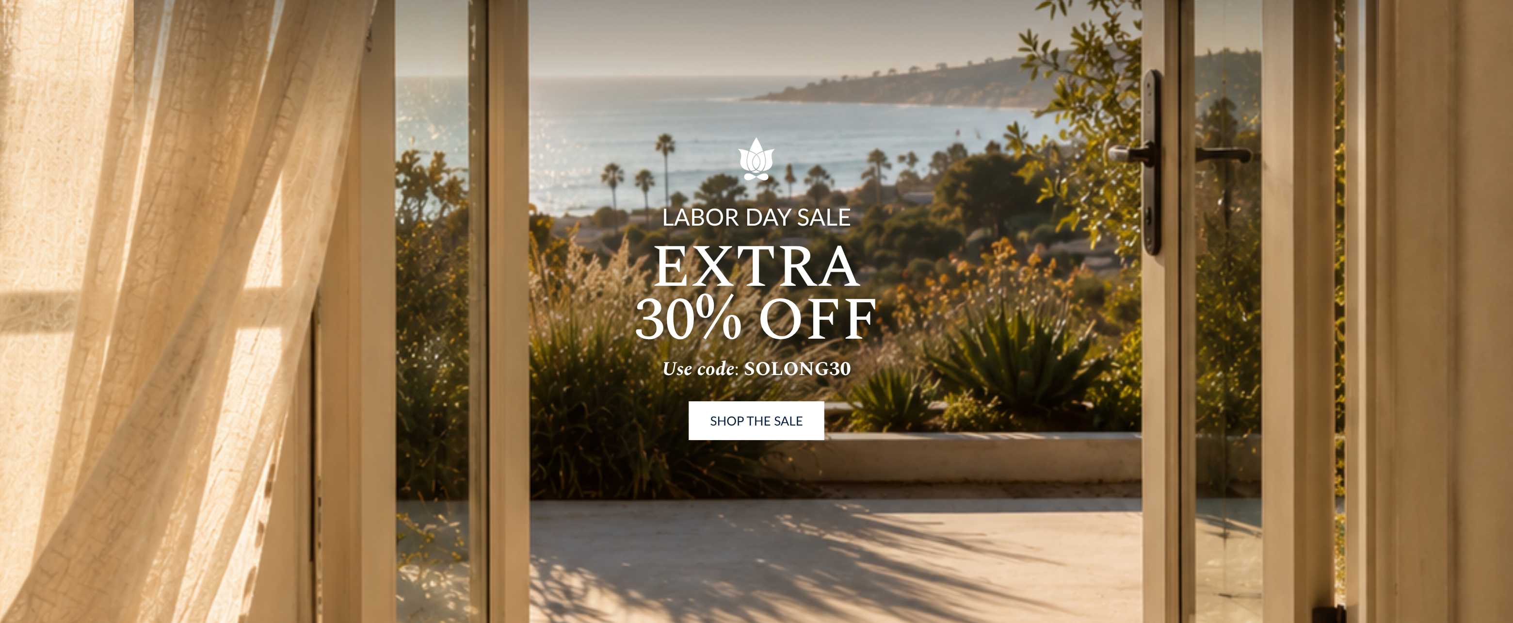 A promotional banner with a coastal outdoor view framed by tall glass doors and sheer curtains. White text in the center reads 'Labor Day Sale Extra 30% Off' with a 'Shop the Sale' button below.