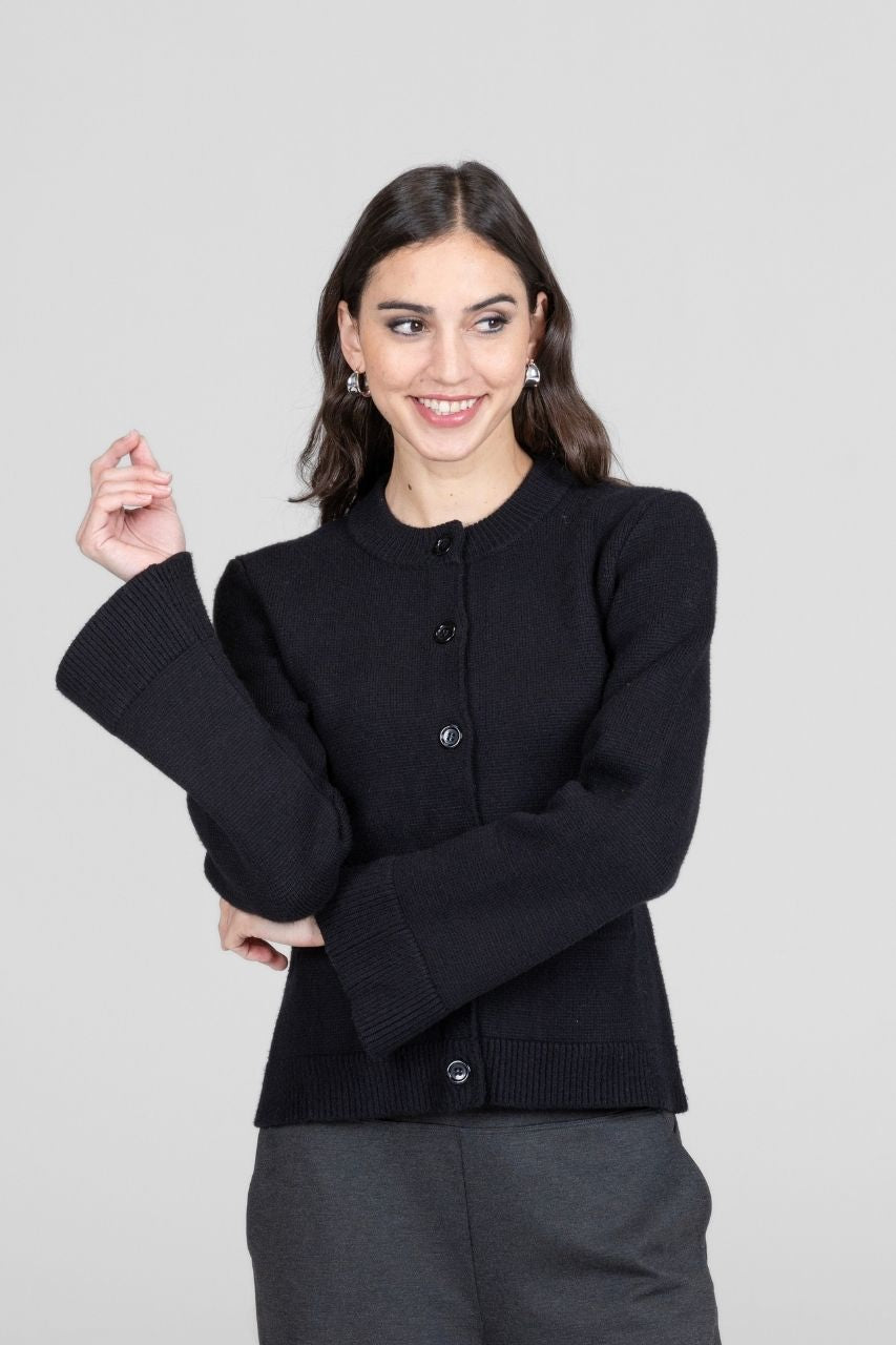 Woman wearing a black cardigan jacket on a light gray background