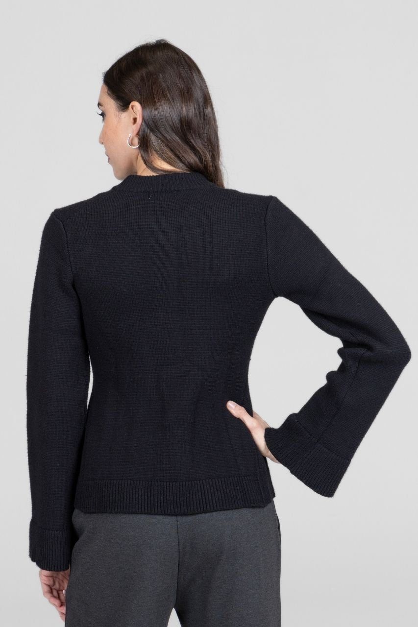 Back view of a woman wearing a black cardigan against a light gray background