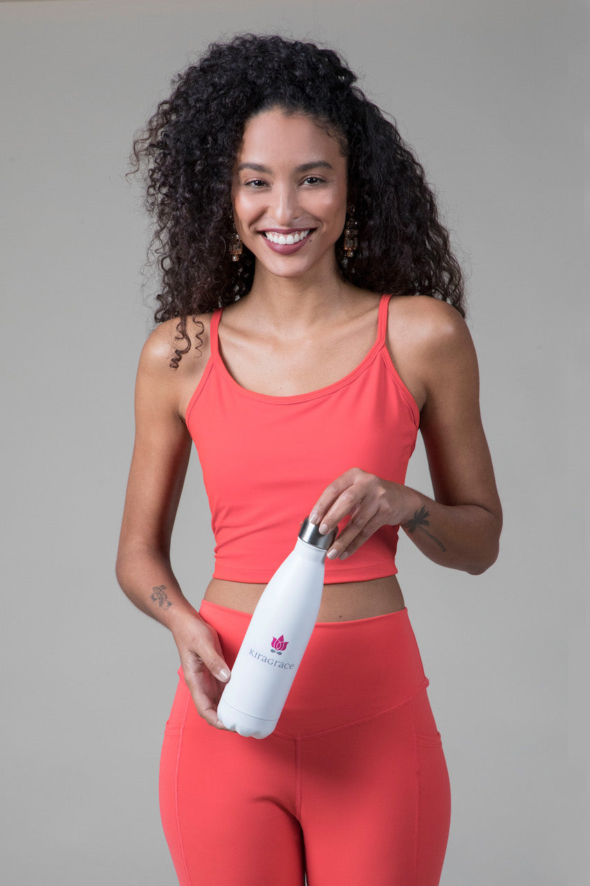 Woman holding white insulated KiraGrace branded water bottle