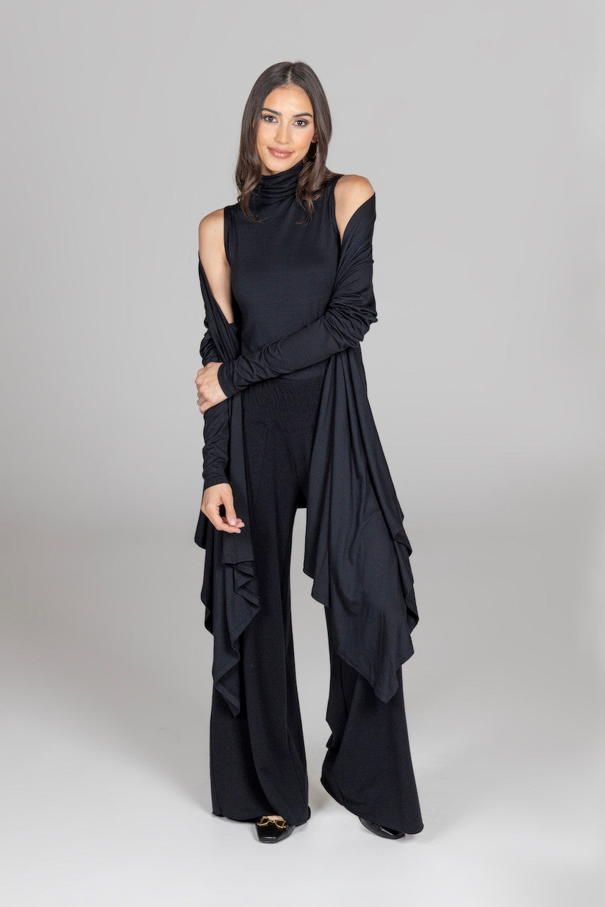 Front view of the sleeveless turtleneck paired with an infinity wrap, highlighting the layered look and chic styling options