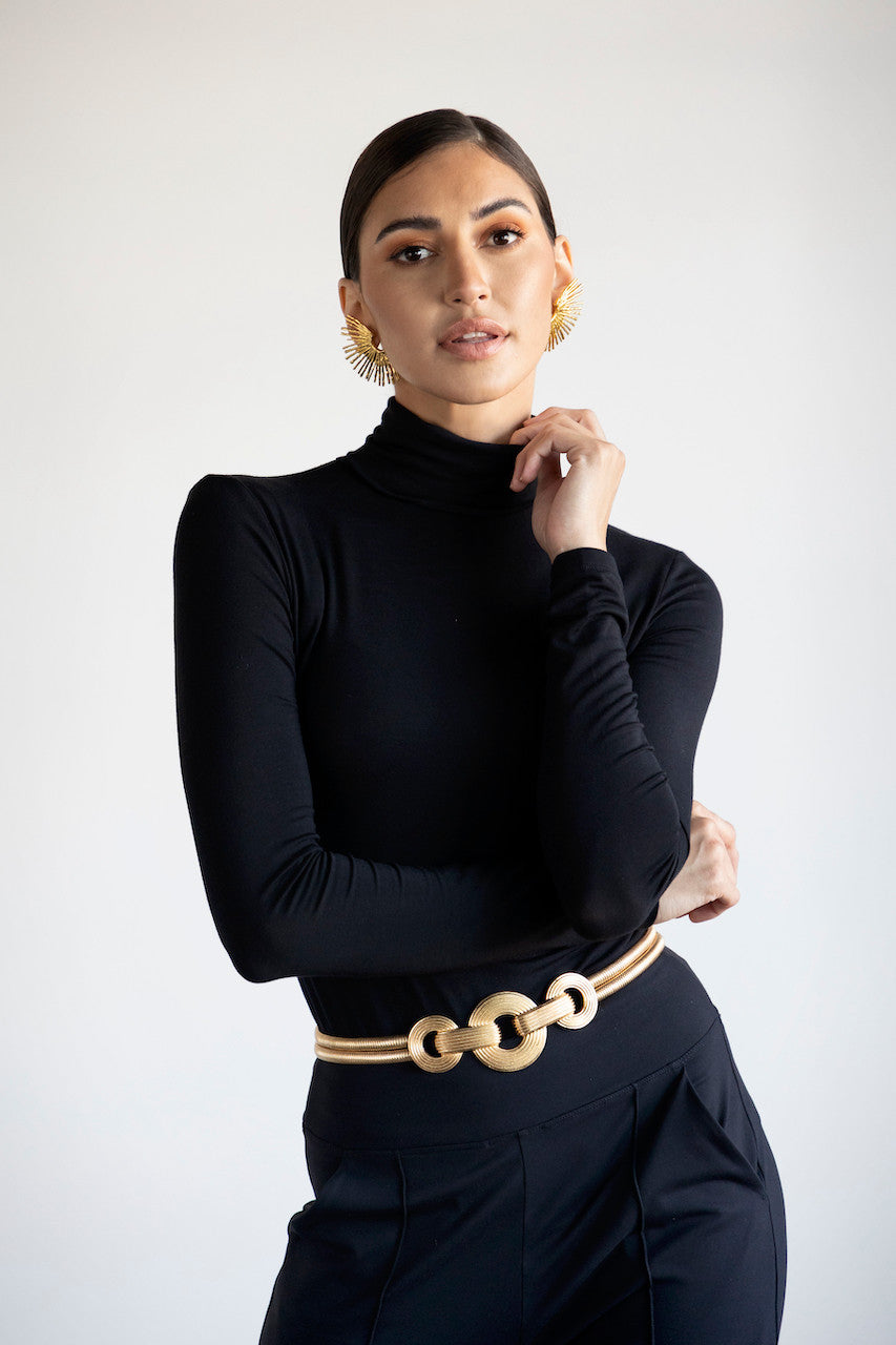 Model with gold jewelry in GRACE TURTLENECK: BLACK