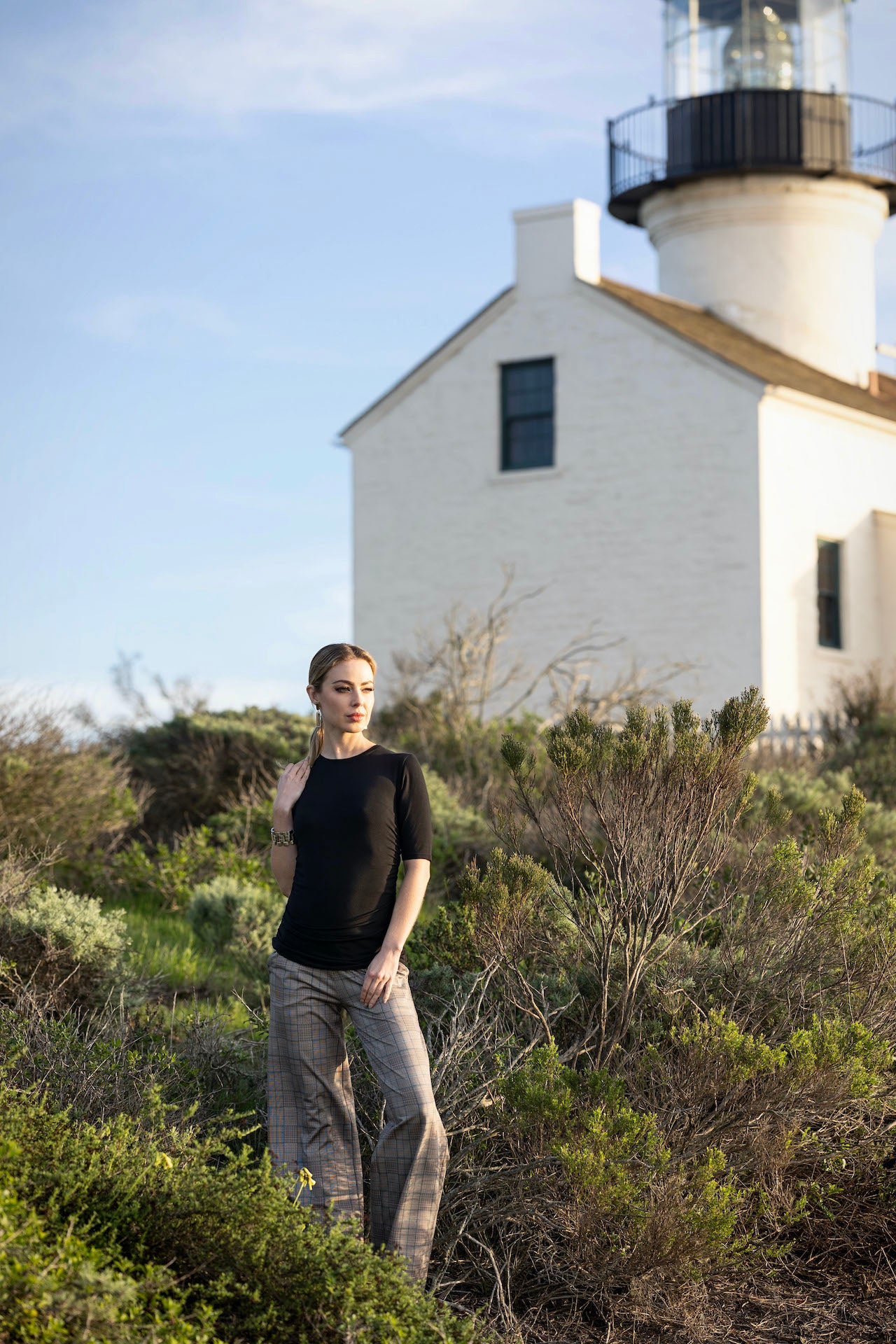 Model in a cottage garden in RUCHED ELBOW SLEEVE TEE: BLACK