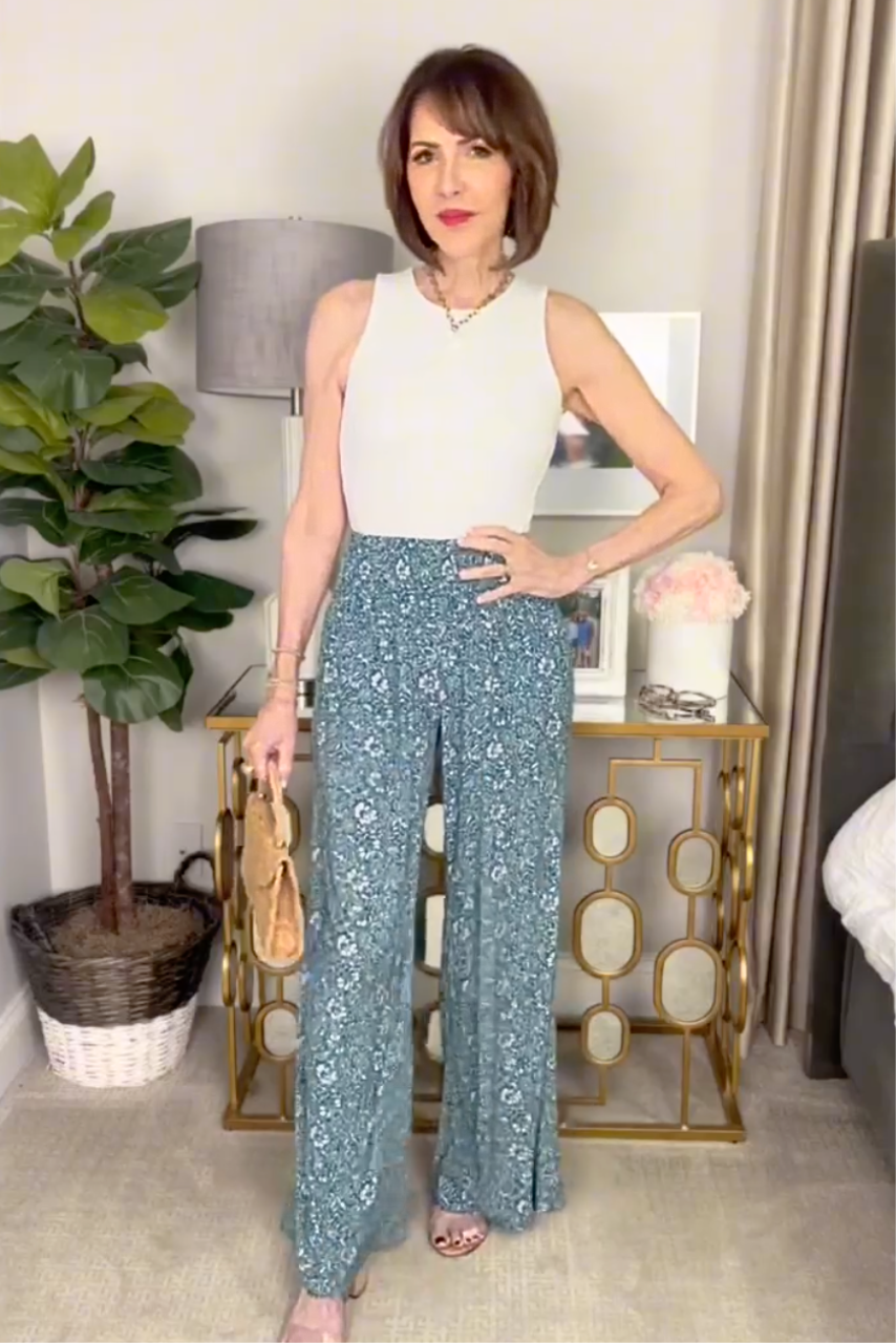 Woman wearing portofino pants in blue batik and blue vines, paired with an ivory travel tank