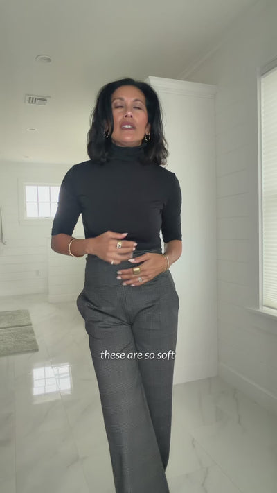 Woman showing and wearing a black turtleneck elbow sleeve top