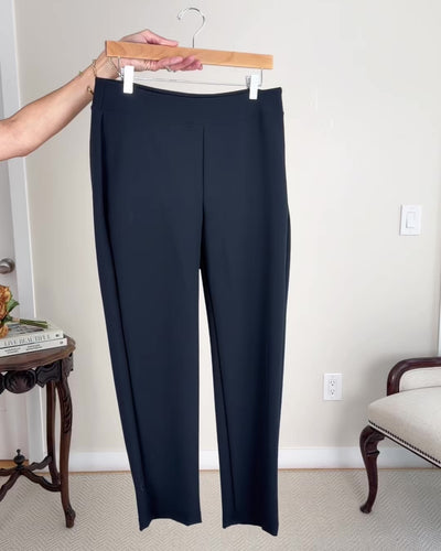 Model putting together outfits consisting of black ankle pants, white tops, a black blazer, flats, sunglasses, a black handbag and a gold clutch bag