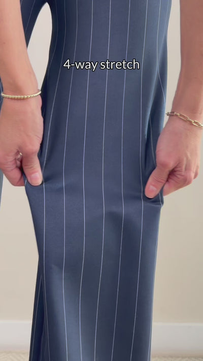 Person stretching navy pinstripe pants to show 4 way stretch