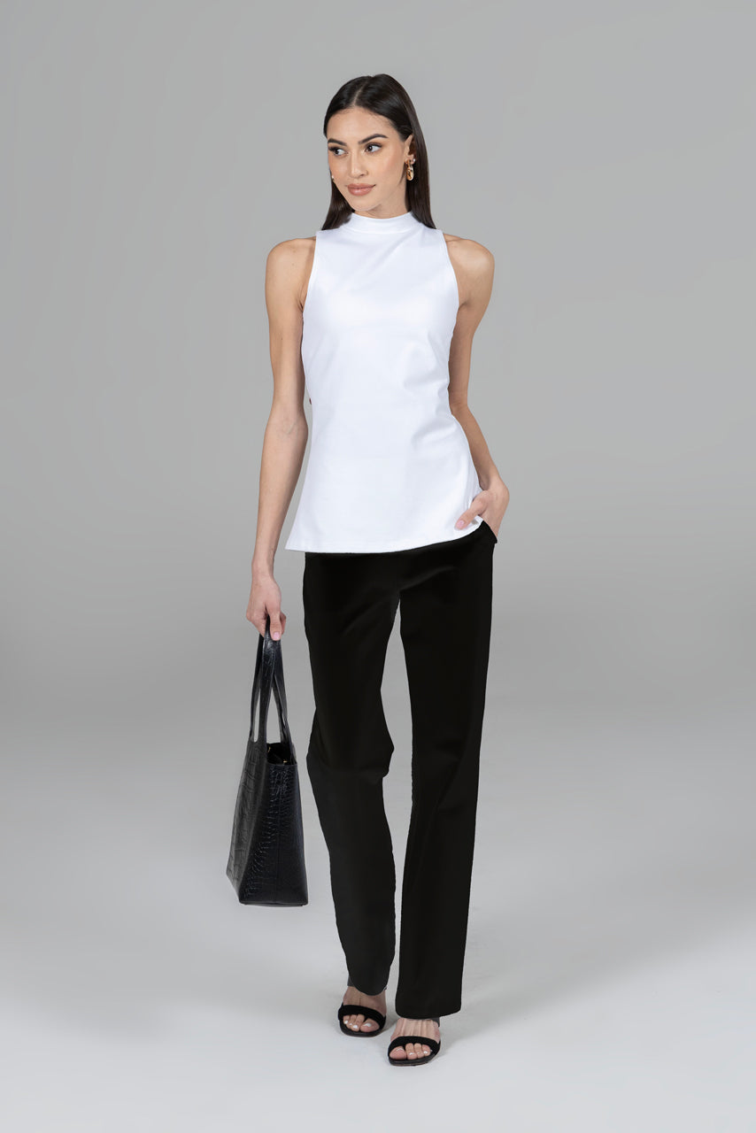 Woman wearing white mock neck top with black straight leg pants
